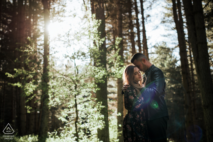 Sessão de casal nas montanhas do parque nacional Sila, Calábria | A imagem contém: abraço, abraço, amor, floresta, árvores, bosque, luz solar