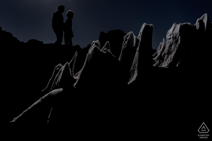 Silhouette de couple du désert d'Atacama encadrée de banquise pendant la séance de photos d'engagement.