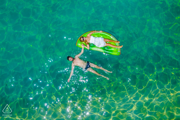 Carlentini summer loving - portrait de fiançailles tourné avec un drone aérien d'un couple de détente dans l'eau.