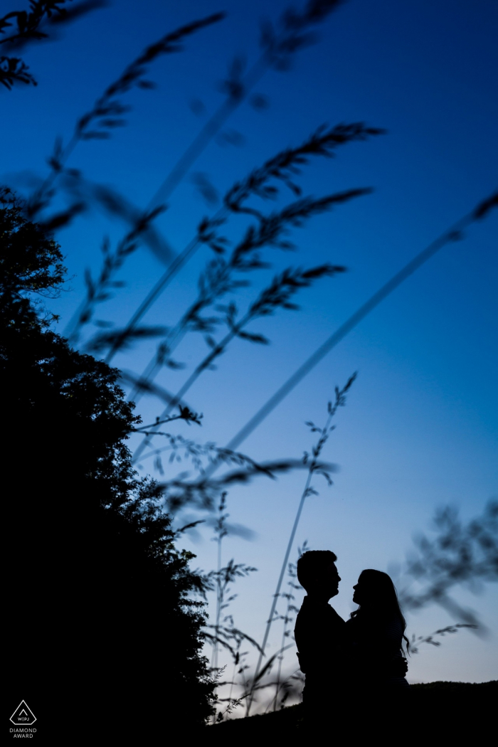 Brno casal posando para um retrato de noivado sob o grande céu azul