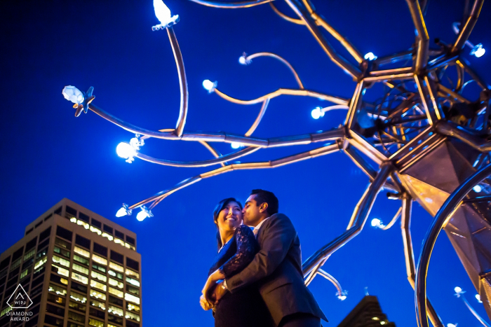 Sesión de fotos de compromiso de San Francisco - Amor en las luces de la ciudad - Una pareja se abraza bajo el arte callejero.