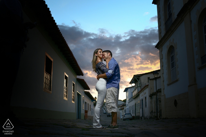 Cidade de Goiás Verlobungsfotosession – Porträt enthält: Umarmung, Paar, Gebäude, Himmel, Sonnenuntergang, Gasse