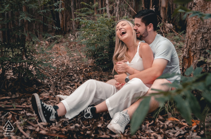 Photo by: <a href="https://www.wpja.com/photos/diamond-award-top-wedding-engagement-photographer/2574756">Lucas Coutinho - Nova Friburgo Rio de Janeiro Parque Municipal Couple laughing together during outdoor engagement shoot under the trees