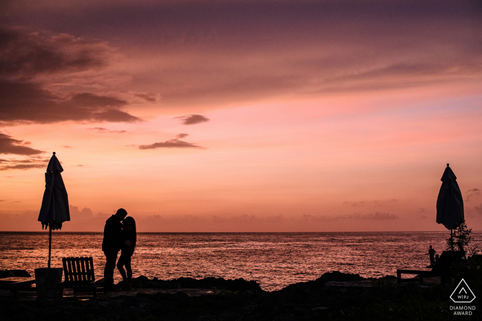 Sessão de retratos da silhueta do pôr do sol de casais em Negril, Jamaica no mar com crianças pescando