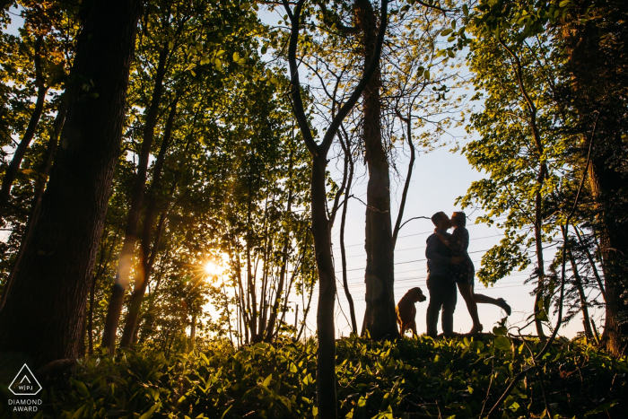 fotógrafo de compromiso de territorio privado sint-niklaas: la pareja se besa recortada por el sol y el cielo