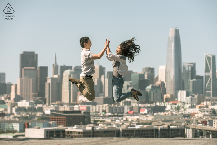 engagement shoot with a Couple jumping in the air and the city in the background San Francisco, CA engagement shoot with a Couple jumping in the air, city in the background.