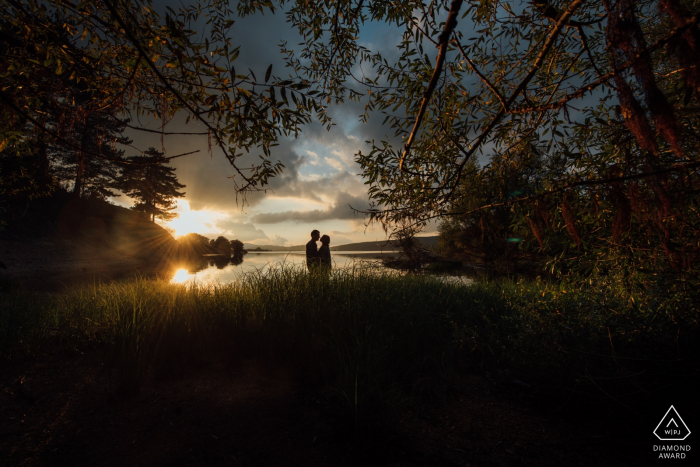 Calabria, Italia sesión de compromiso íntimo al atardecer con una pareja junto al agua.