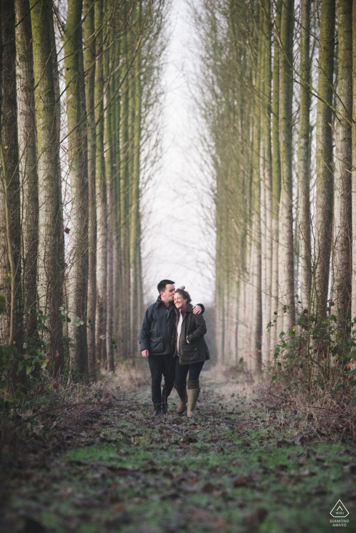 Casal Bridgnorth andando durante a sessão de retrato na floresta alta