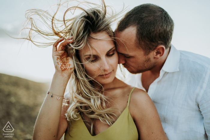 A couple with their hair blown in the wind during engagement portraits in Désert d'Agafay