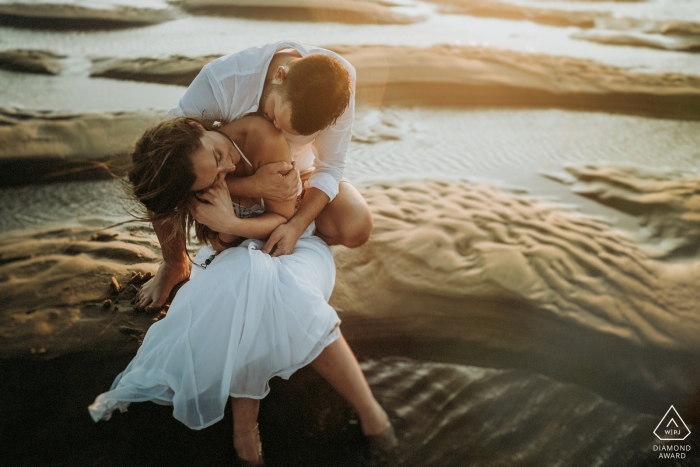 Engaged couple couple sitting on the beach at sunset for portraits in Royan, Charente-maritime France 