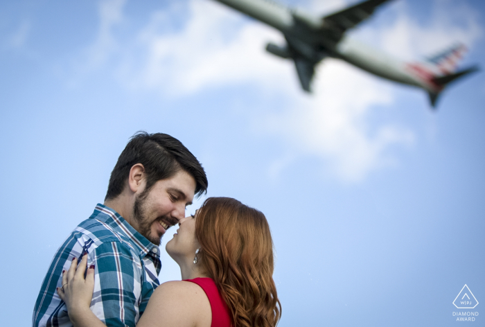 pre-wedding photography of The couple taking time to gaze into each other's eyes instead of watching the departing jet Gravelly Point Park, Arlington, VA pre-wedding photographer: The couple was taking time to gaze into each other's eyes instead of watching the departing jet