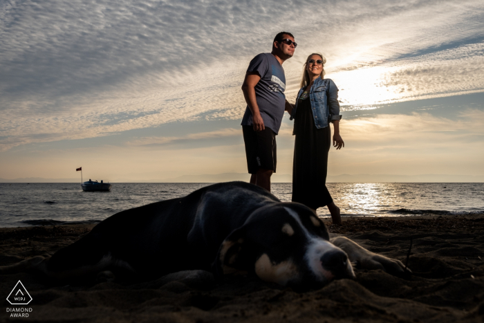 Paar steht hinter dem Hund am Meer in Badavut, Ayvalık, Balıkesir