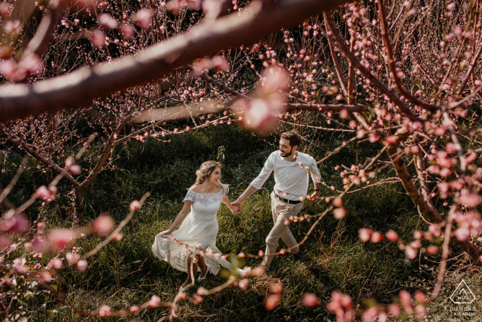 Photo by: <a href="https://www.wpja.com/photos/diamond-award-top-wedding-engagement-photographer/2579521">Renan Radici - Porto Alegre Rio Grande do Sul Bento Goncalves pre-wed photo session of a couple running in the peach fields.