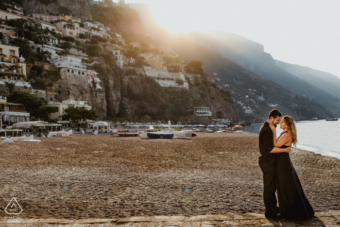 Casal ao nascer do sol na praia de Positano durante a sessão de fotos de noivado.