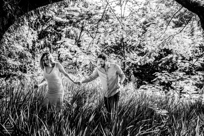 Campinas - São Paulo couple walk on the gress in a black and white photo session for engagment portraits