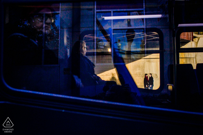 Park Engagement image of A couple framed in a bus passing by Wicker Park Chicago, IL Engagement | A couple is framed in a bus passing by.