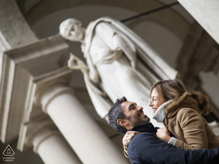 Foto di fidanzamento a Milano in Italia - Immagine di una coppia con una statua dietro di loro