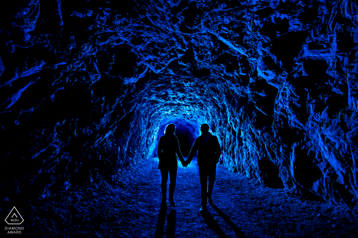 Zukünftige Braut und Bräutigam gehen durch dunklen Tunnel in Canon City, Colorado.