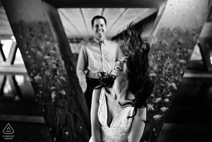 Couple under a bridge in Canterbury. The girl laughing and the guy in the background during their prewed portrait.