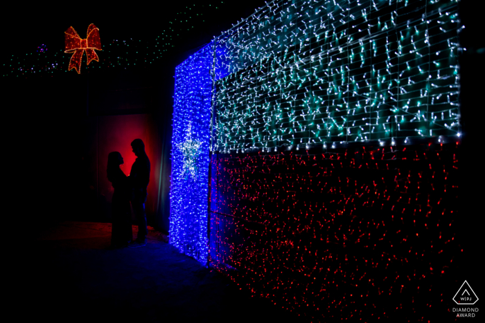 Photo by: <a href="https://www.wpja.com/photos/diamond-award-top-wedding-engagement-photographer/2580145">Jill Goehring - Houston Texas Sugarland, TX Couple's Portrait with red and blue lights indoors.