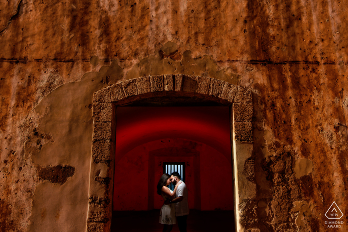 El Morro, San Juan Fotógrafo de noivado no pré-casamento em PR: Gel vermelho nas costas para destacar o enquadramento.