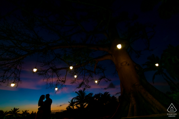 Dorado, PR fotografo di matrimoni: usa il tramonto per far apparire la silhouette della coppia mentre inquadra con le luci dell'albero.