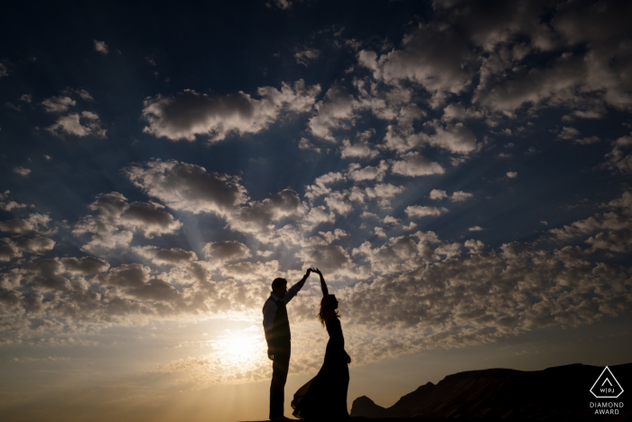 Desert Couple Dancing in the Desert under the Clouds and Blue Sky for engagement portraits Fossil Rock, Dubai Desert Couple Dancing in the Desert under the Clouds and Blue Sky