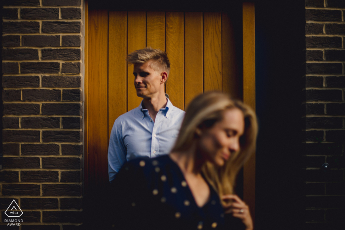 Creative pre-wedding shoot with a brick buiding and a wooden door Engaged Couple Session | London Creative pre-wedding shoot