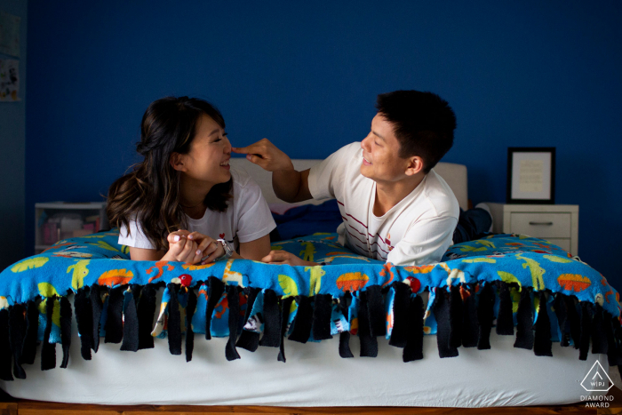 los angeles couple in bed with blue background - in-home engagement shoot