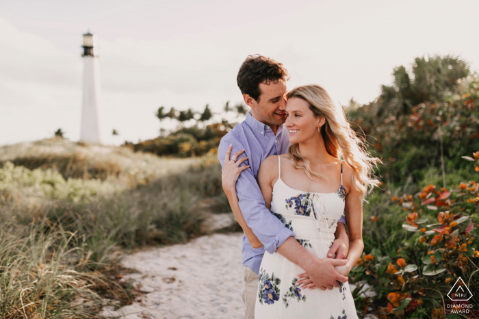 State Park couple embrace portrait at the beach with a lighthouse Engagement Photographer | Bill Baggs State Park, Key Biscayne, Florida couple embrace