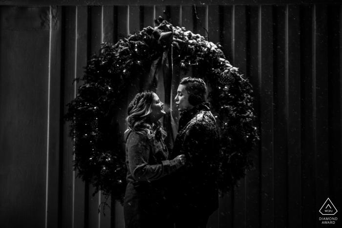 Duluth Minnesota engagement session couple blowing air on a freezing cold night during a blizzard. 