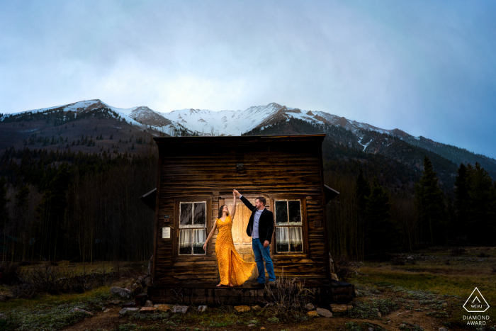 The gentleman twirls his fiance in front of an abandoned schoolhouse, which is part of a Ghost Town in rural Winfield, Colorado.  