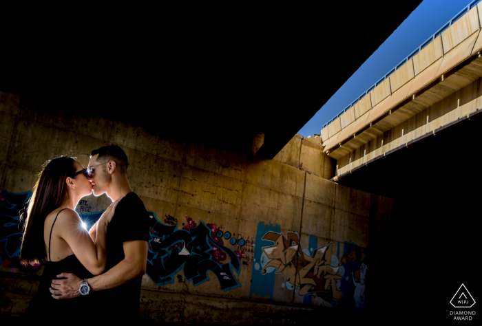 A couple kiss in the shadows of a bridge in Aguilas, Spain