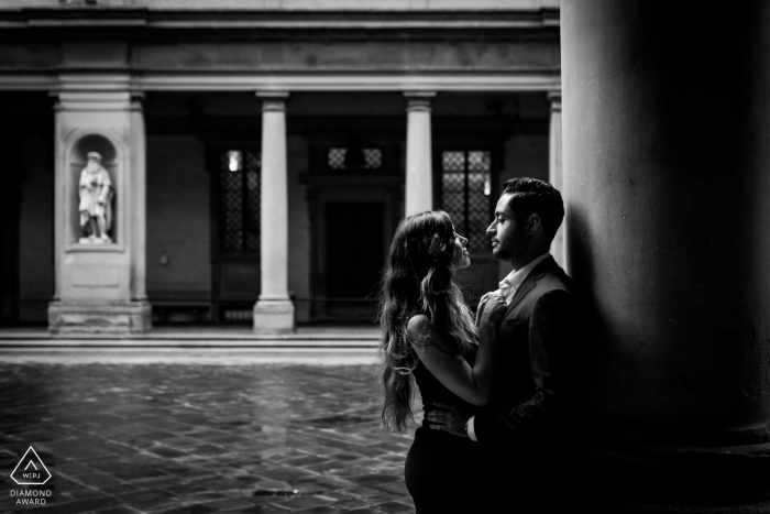 A couple during an engagement shoot under the corridor of the Uffizi Gallery in Florence