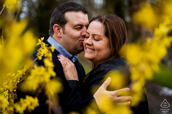 Engaged couple embrace each other during a portrait session at the Hotel with fall colors Engaged couple embrace each other during a portrait session at Rushton Hall Hotel and Spa