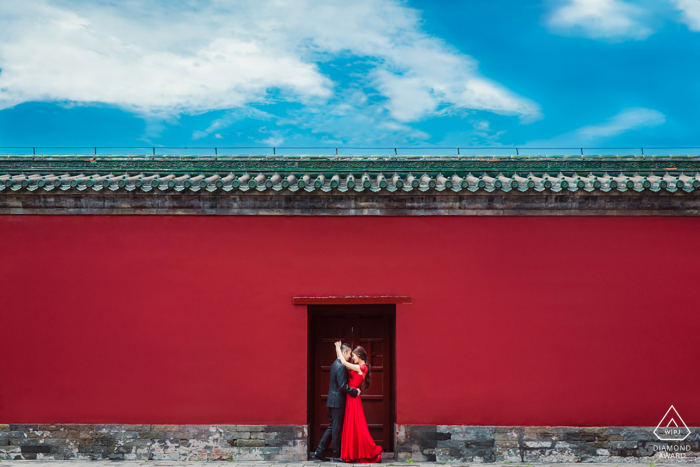 La pareja está junto a la antigua muralla del edificio histórico en el Templo del Cielo.