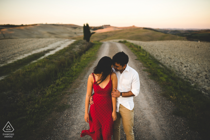 prewed photoshoot of a couple on a country road with rolling hills and beautiful fields Tuscany prewed photoshoot of a couple on a country road with rolling hills and beautiful fields