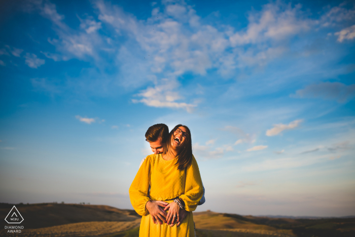 Engagement photo session in Tuscany with a big blue sky and white clouds