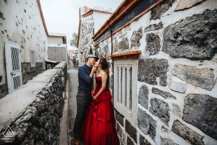 La pareja de Penghu se muestra afecto el uno al otro durante su sesión de fotos de compromiso entre una red de edificios de piedra