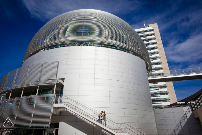 Newly engaged couple pose for a portrait on the stairway of the San Jose City Hall Rotunda 