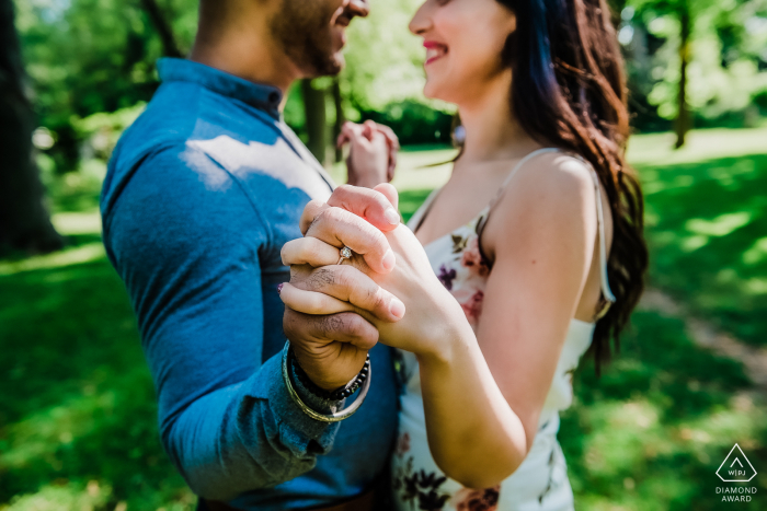 Face to face couple hold hands outstretched for an engagement portrait Face to face couple hold hands outstretched for an engagement portrait in Toronto, Ontario