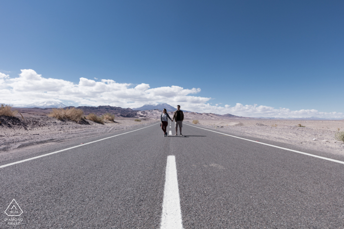 Open road and painted lines lead you right to the engaged couple in the desert Open road and painted lines lead you right to the engaged couple in the atacama desert