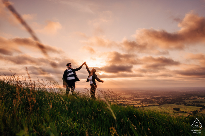 Coppia danzante sulla collina al tramonto al Devil's Dyke, vicino a Brighton, Regno Unito