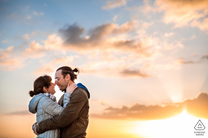 Brighton, Reino Unido Retrato de compromiso de amor al atardecer con un cielo brillante y grandes nubes