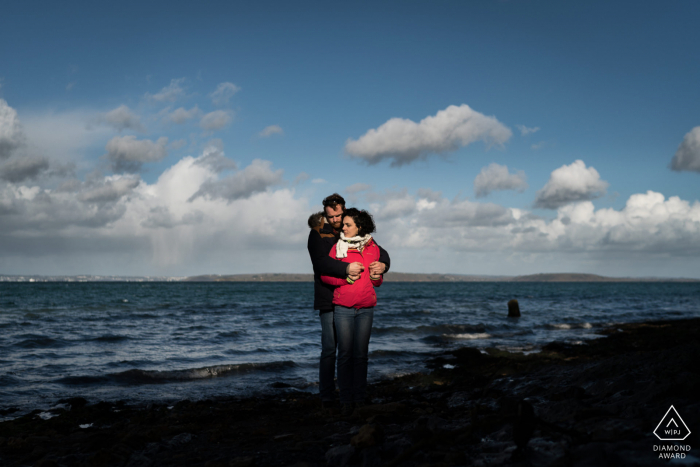 France couple portrait at the beach in a red jacket Crozon, France couple portrait at the beach in a red jacket