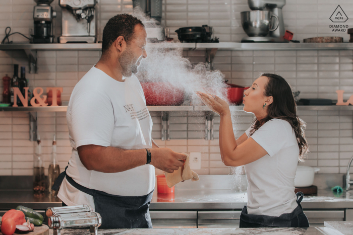 Casal brinca de cozinhar em uma cozinha durante uma sessão de fotos em Belo Horizonte, Brasil