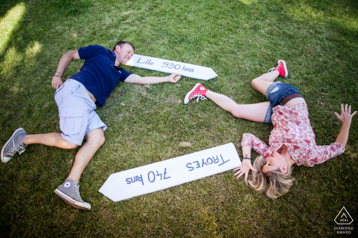 A couple with their native town signs lying on the grass lawn of Nougaroulet, Gers, France