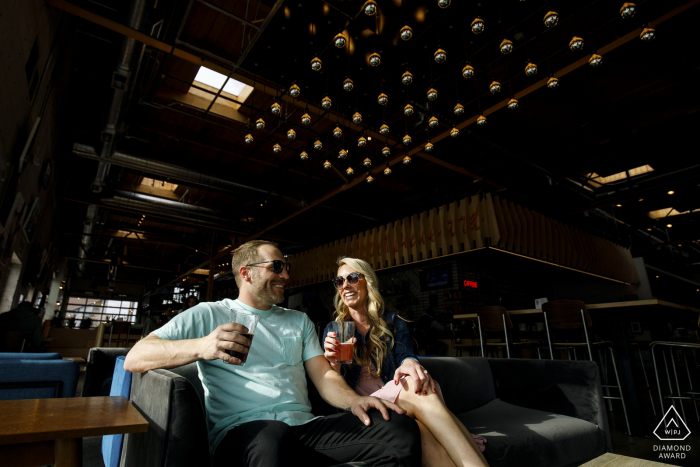 The young couple share a drink at Improper City in Denver during their engagement photos