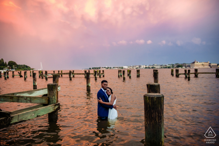 Sessão de retrato de noivado de Annapolis Maryland na água com um pôr do sol do arco-íris duplo