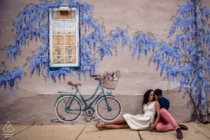 Annapolis Maryland pareja comprometida sentado para un retrato bajo el muro de Wisteria